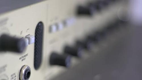 Close up of knobs and switches on a audio recording device. A headphone amplifier. Smooth sliding ca