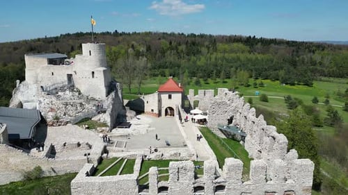 Medieval Rabsztyn castle with a turret, walls, and courtyard during a beautiful summer day surrounde