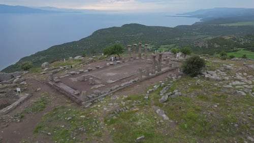 Drone Lifting Away From Ancient Assos Temple with Sea and Hills View
