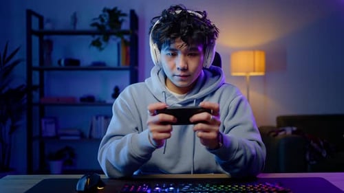 Concentrated Gaming on Mobile Phone at Night