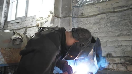 Welder Sparks Flying in Dark Workshop