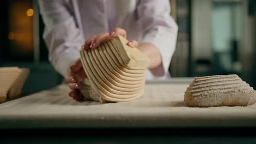 female baker's hands lay out raw buns dough from molds before baking production of bakery products