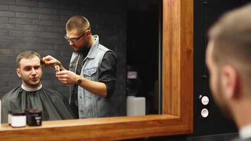 Barber Trimming Hair with Electric Razor in Shop