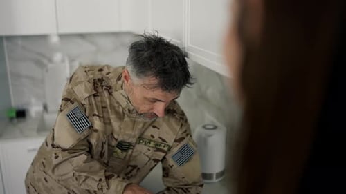Soldier Leaning on Counter Talking Indoors
