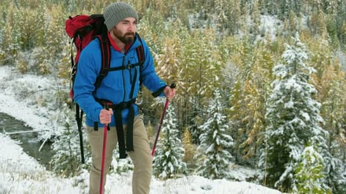 Hiker Walking in Winter Snowy Forest Tourist Man with Big Backpack Walking Along the Road in
