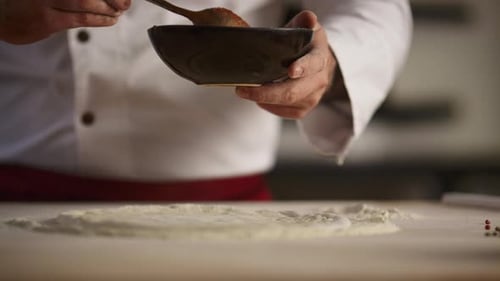 Chef Cooking Italian Pizza on Wooden Board. Unrecognizable Man Hands Spreading Tomato