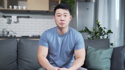 Young Adult Man Talking on Video Call at Home