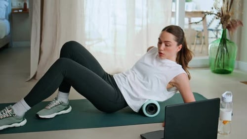 Woman Using Foam Roller for Back Exercise at Home