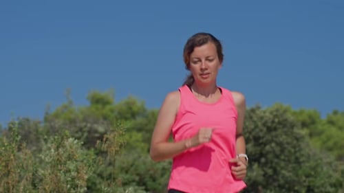 Woman Jogging on Rocky Trail in Nature Endurance Training