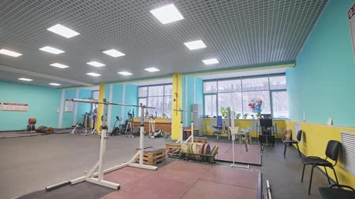 Holder with Barbell and Racks with Circle Weights in Gym