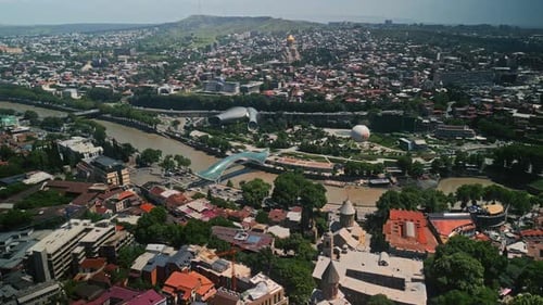 Aerial View of Tbilisi City Featuring a Blend of Modern Architecture Historic Churches and the Kura
