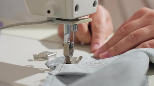 Close Up Sewing Machine Stitching Fabric With Female Hand Guiding Material