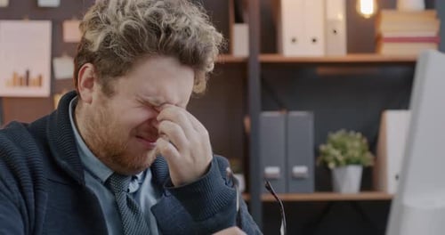 Loop of Businessman Taking Off Glasses and Rubbing Eyes Feeling Tired Working Late in Evening in