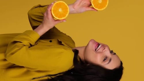 Young Woman with Oranges in Yellow Setting