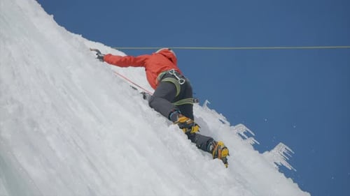 Slow Motion Shot Of Expert Person Climbing Iced Mountain Using Axe
