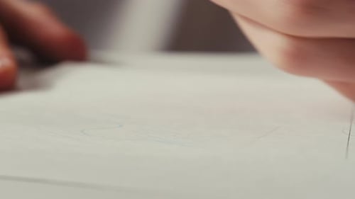 Drawing with Blue Pencil on White Paper Close Up