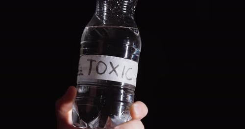 Toxisches Etikett auf der Wasserflasche in Nahaufnahme — Kontaminations- und Gefahrenkonzept