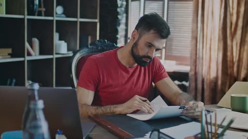 Young Businessman Reading Documents In Office. Beard Man Working With Paper Documents In Cozy Off...
