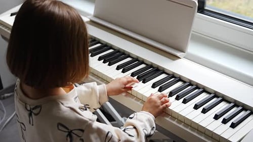 Child Plays Piano in Brightly Lit Home