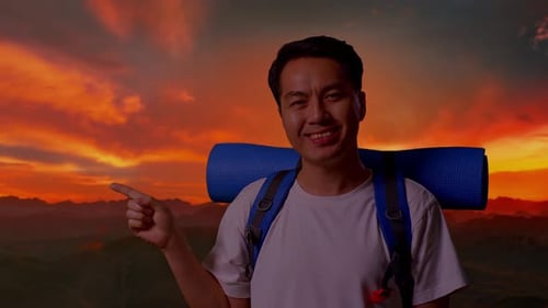 Close Up Of Asian Male Smiling And Pointing To Side On Top Mountain