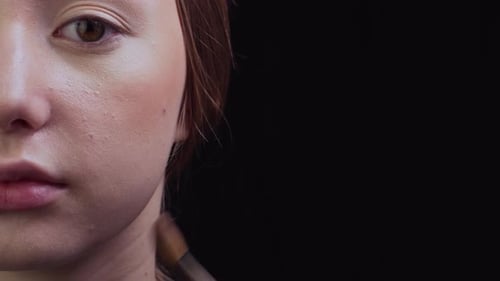 Applying Makeup to Woman's Face With Brush Close Up