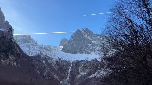 Snowy Mountains and Contrails on a Sunny Winter Day