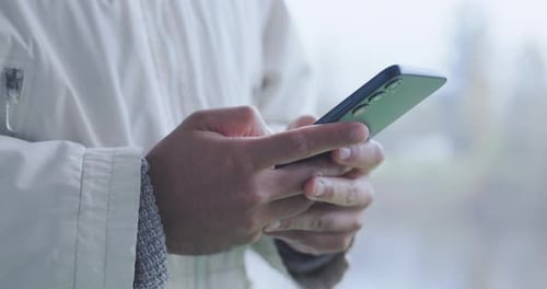 Person Typing on Smartphone Device Outdoor