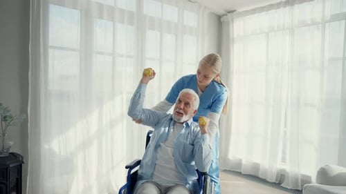 Senior Man Exercising with a Nurse in Home