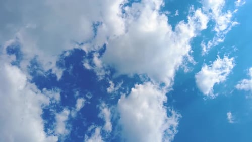 Himmel, Zeitrafferwolken und blauer, sonniger Himmel, Schleife weißer Wolken über blauem Himmel mit Sonnenstrahlen, Luftbild