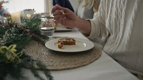 Close up of plate with Christmas cake and man with family eating them. Shot with RED helium camera i