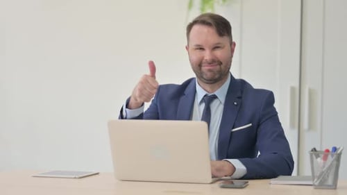 Professional Man Giving Thumbs Up in Modern Office