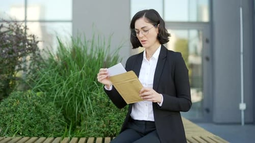 Woman Reads Bad News While Sitting Outside