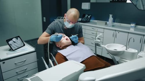 Dentist Performing Dental Procedure on Patient in Clinic
