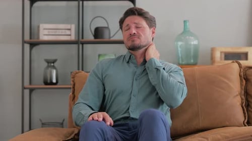 Adult Man Rubbing Neck in Discomfort
