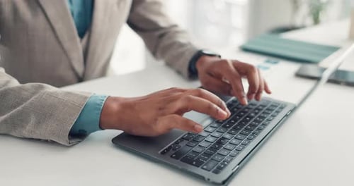 Man Typing on Laptop at Desk in Office