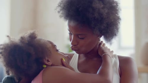 Loving Mother Embraces Young Daughter with Affection