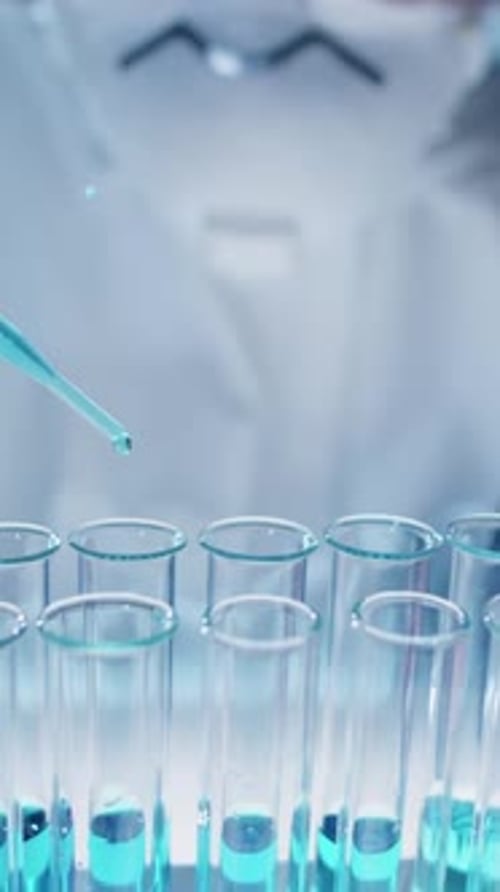 Close-up of Unrecognizable Scientist Pipetting Liquid into Test Tube in Lab