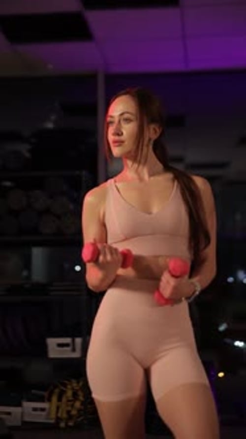 Woman Lifting Dumbbells in Modern Gym to Build Strength and Performance Vertical Video