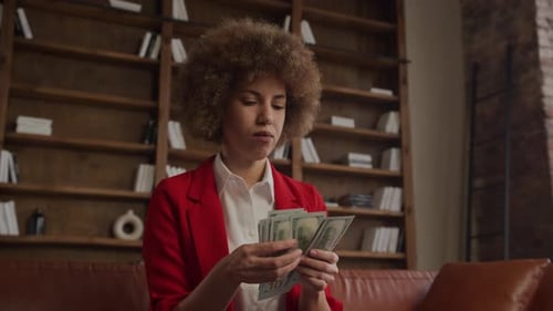 Woman Counting Stack of Cash Indoors