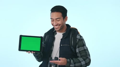 Happy asian man, tablet and hiking with green screen or mockup in advertising against a studio