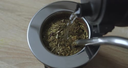 Pouring boiling water into a used black mate glass. 4K
