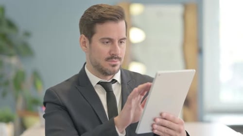 Man in Suit Using Tablet in Office