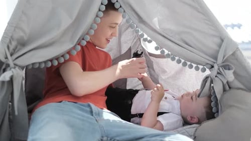 Les enfants installent une tente dans un endroit ensoleillé de la cour, explorant leur imagination en jouant à des jeux