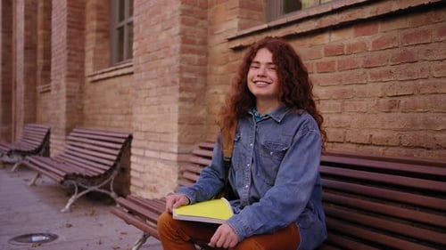 Portrait of Young Happy Caucasian Red Head Student Outside the University Building Looking at Camera