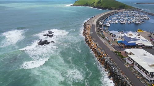 Ocean Waves Crashing On Breakwater Of Coffs Harbour Near Muttonbird Island - Sailboats Moored At Jet