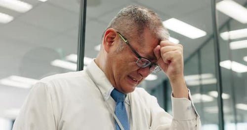 Stressed Adult in Office Rubbing Forehead