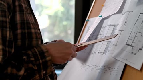 Architectural Plans Being Reviewed on a Notice Board