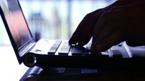 Man hands typing on laptop keyboard close up in modern office