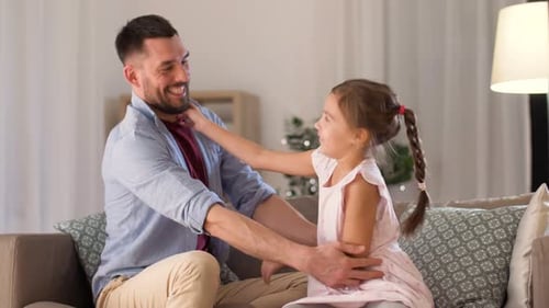 Happy Father and Daughter Playing Together on Couch