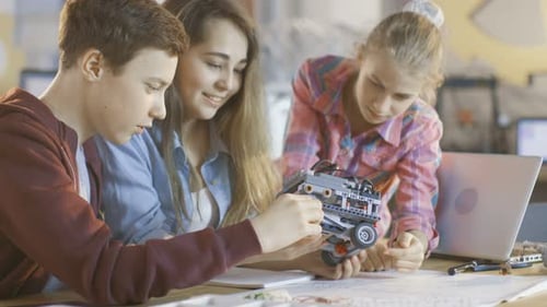 Two Girls and a Boy Work with Robotics for Science Class Project.